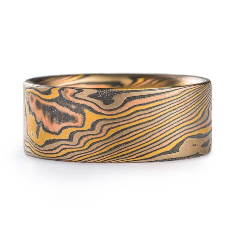 wide mokume gane twist patterned ring with a flat profile, ring is made with layers of red and yellow gold, palladium and oxidized silver