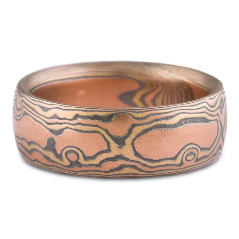 wide mokume gane domed band, made with red gold, yellow gold and oxidized silver, in a woodgrain style pattern
