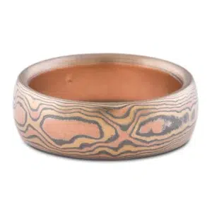 warm toned mokume gane band patterned to look like woodgrain