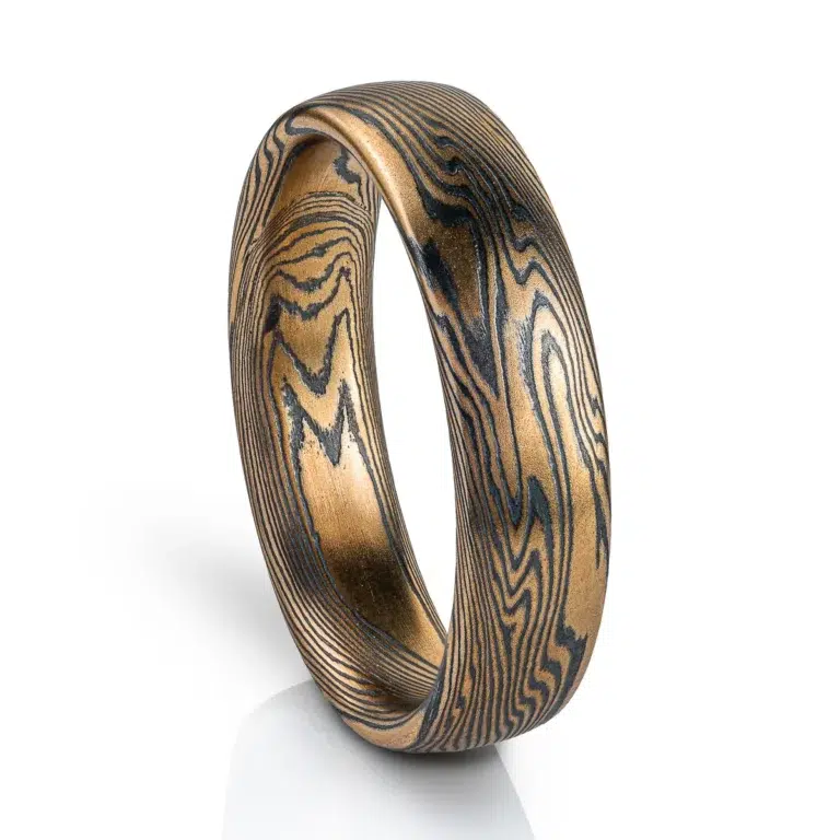 Mokume gane ring mens wedding band High contrast mokume gane mens wedding band ring. Unisex. Gold and blackened oxidized black sterling silver unique nature inspired woodgrain patterned two toned tone yellow white gold alternative metal