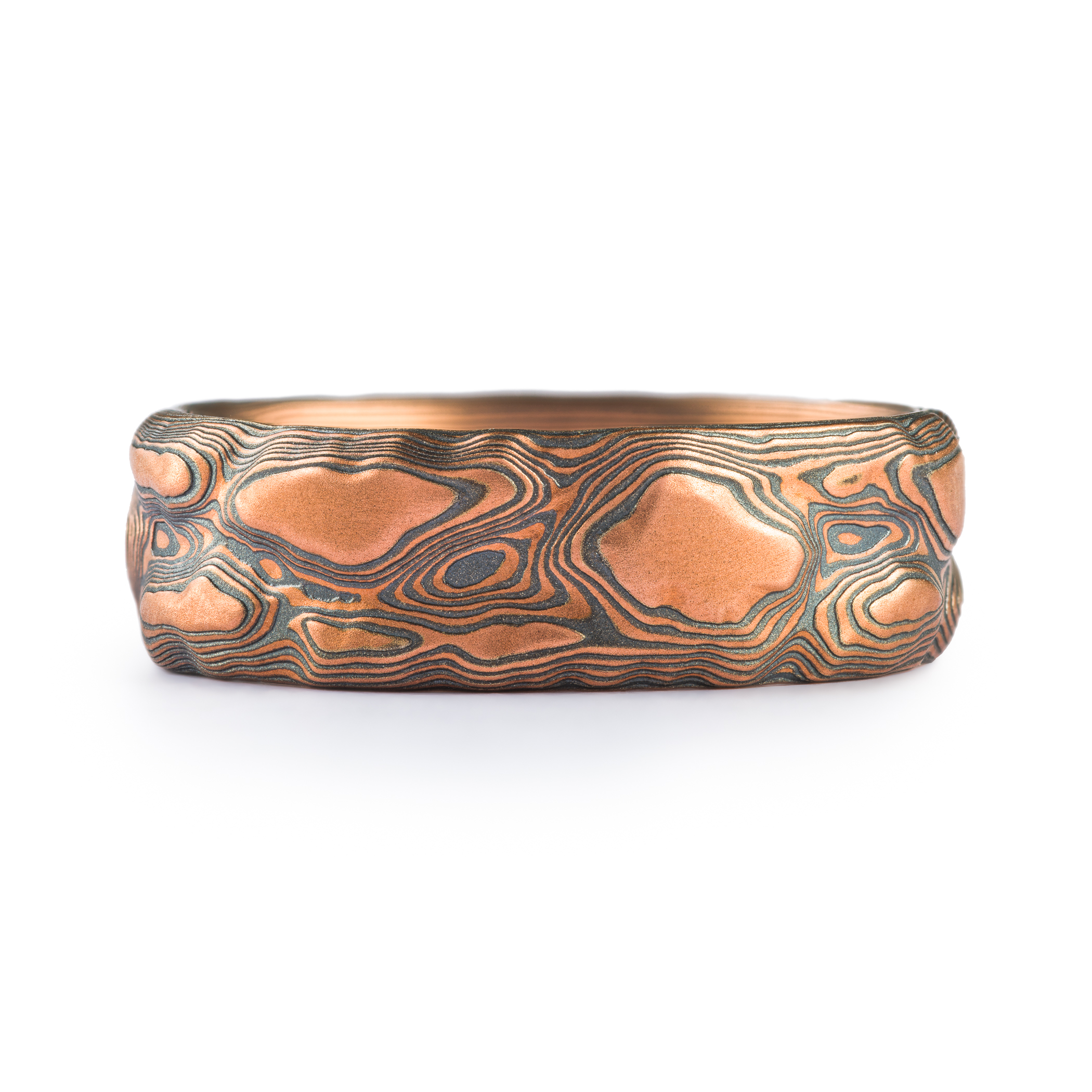 Textured mokume gane ring resembling topography or rock texture, made with red gold and oxidized silver.