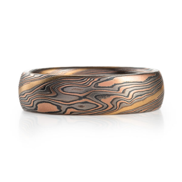 hand carved and handmade twisted metal and stripes of gold. yellow gold , red gold, silver and palladium swirled metal. wide, carved ring for a man
