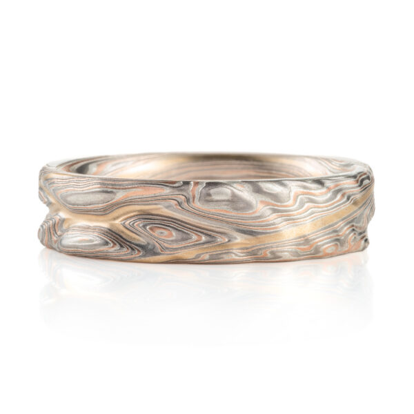 hand carved and handmade twisted metal and stripes of gold. iyellow gold , red gold, silver and palladium swirled metal. wide, carved ring for a man
