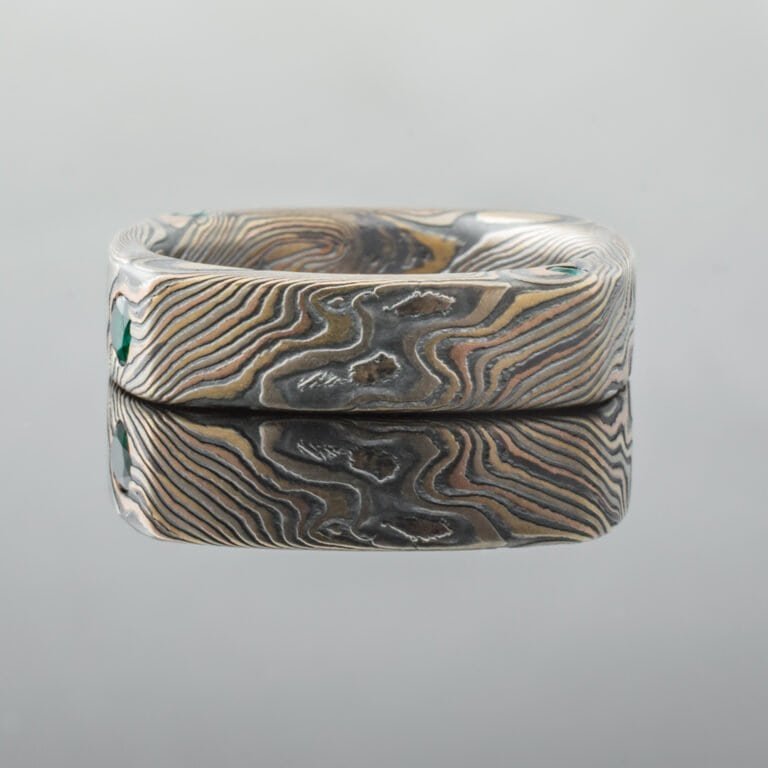 unique style square shaped band in mokume twist pattern, with small flush set emeralds