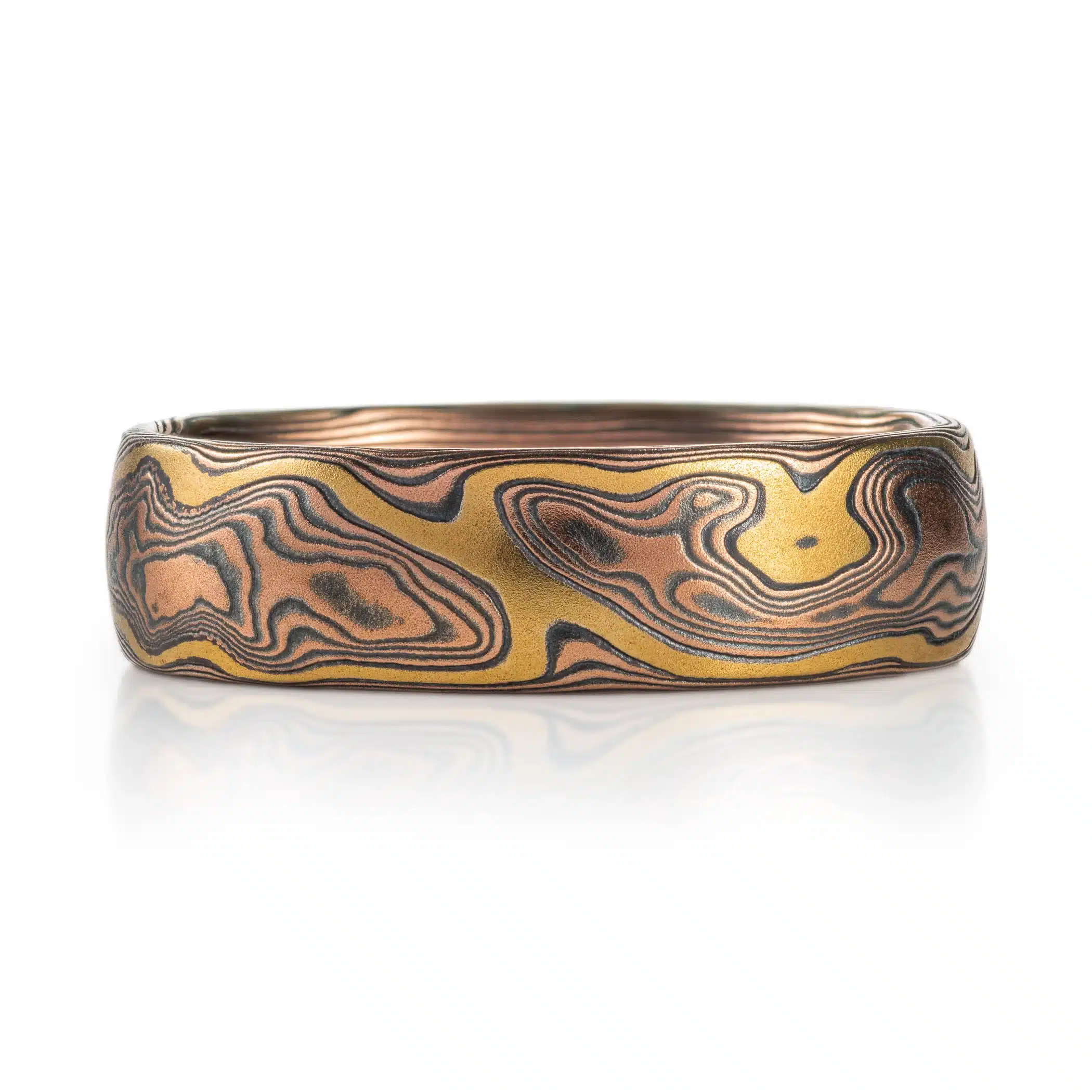 unique style mokume gane ring made in woodgrain pattern, mainly made with red gold and oxidized silver, with an added layer of yellow gold that looks like a river of yellow gold running throughout the ring