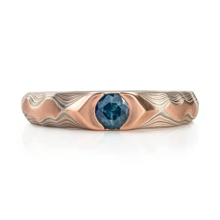 Arn krebs mokume gane ring in guri bori pattern, red gold prominent with a blue sapphire