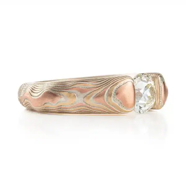 mokume gane tension set ring with diamond in guri bori pattern and gold and silver