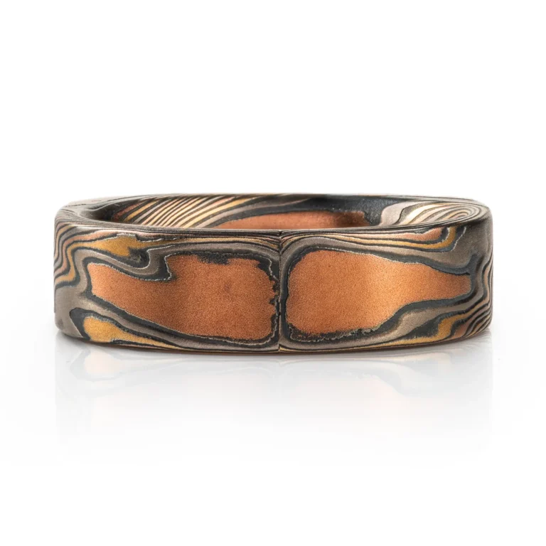 uniquely profiled soft square shaped mokume gane ring with a thicker top section - somewhat similar to a signet style ring, but rectangular, with a small cognac diamond flush set into a corner