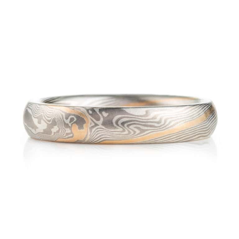 small narrow band made in twisted mokume pattern, overall silvery palette with added stripe of yellow gold as an accent