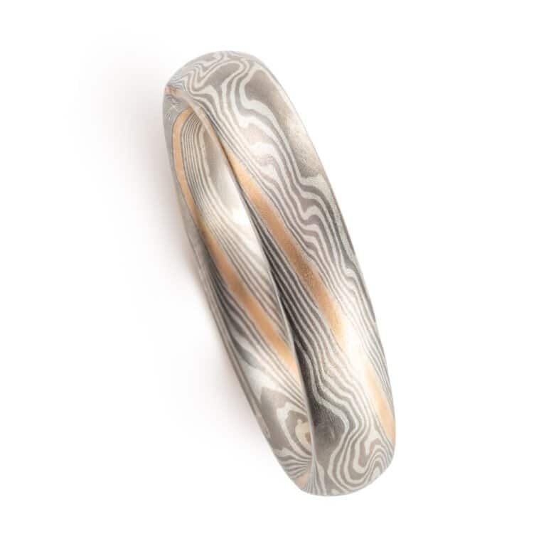 small narrow band made in twisted mokume pattern, overall silvery palette with added stripe of yellow gold as an accent