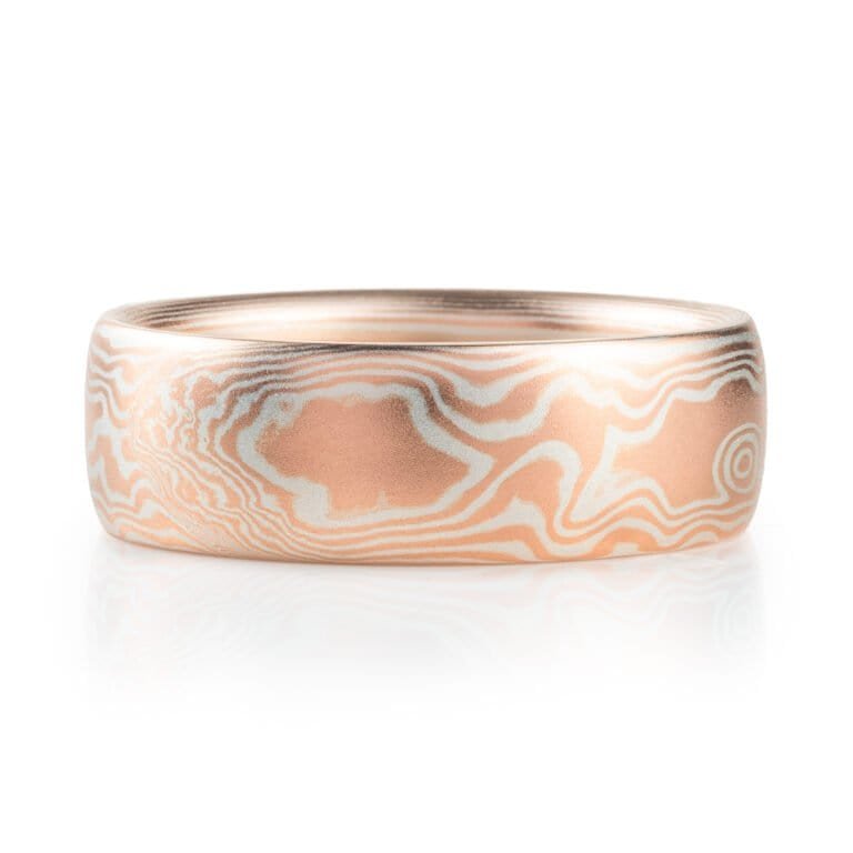 mokume gane wedding band in a woodgrain pattern, red gold and silver