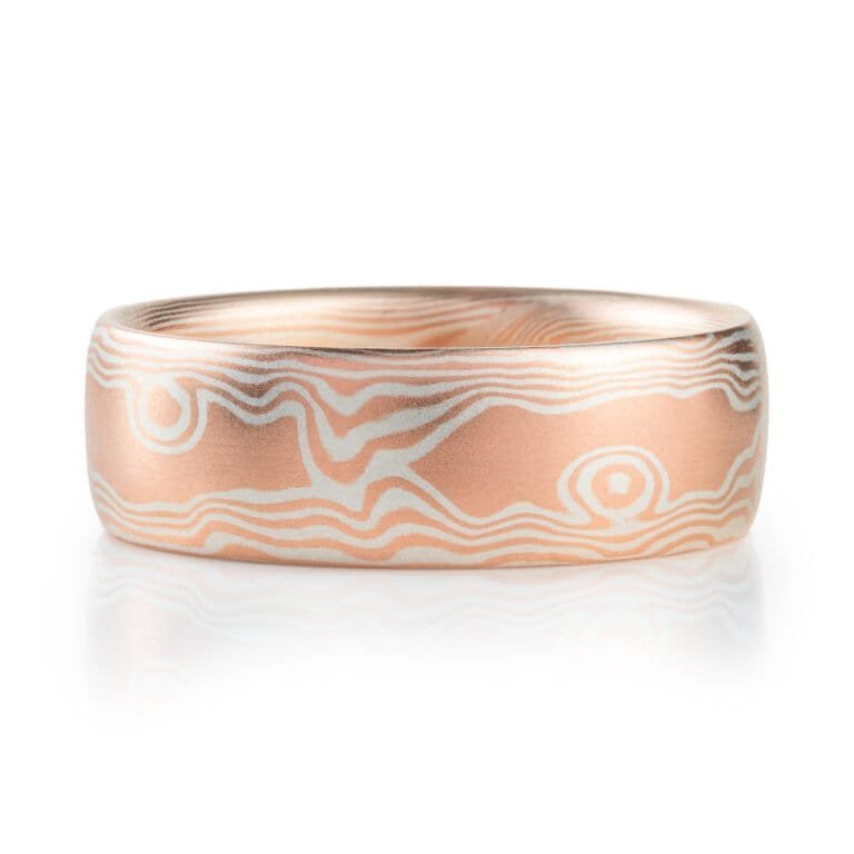 mokume gane wedding band in a woodgrain pattern, red gold and silver