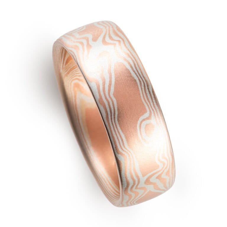 mokume gane wedding band in a woodgrain pattern, red gold and silver