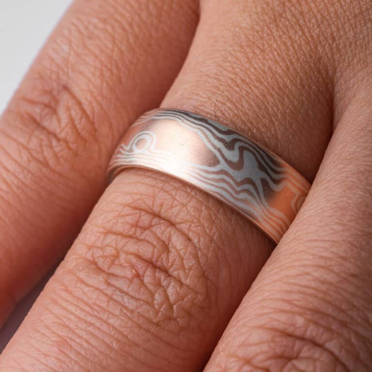 mokume gane wedding band in a woodgrain pattern, red gold and silver