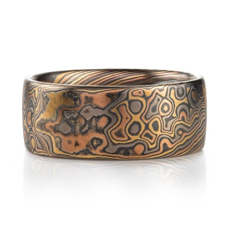 Wide mokume gane ring shown in combination pattern, Twist and Droplet for a mixture of flowing lines and a speckled affect intended to resemble drops of water rippling on a surface