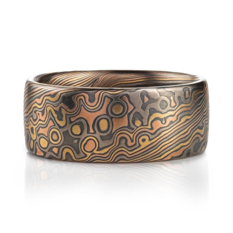 Wide mokume gane ring shown in combination pattern, Twist and Droplet for a mixture of flowing lines and a speckled affect intended to resemble drops of water rippling on a surface