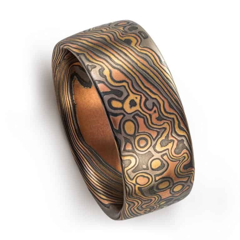 Wide mokume gane ring shown in combination pattern, Twist and Droplet for a mixture of flowing lines and a speckled affect intended to resemble drops of water rippling on a surface