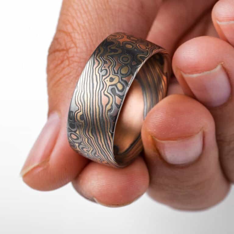 Wide mokume gane ring shown in combination pattern, Twist and Droplet for a mixture of flowing lines and a speckled affect intended to resemble drops of water rippling on a surface