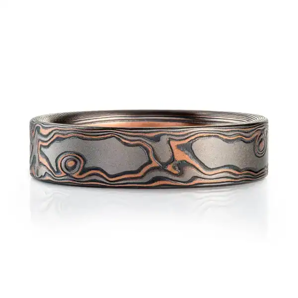 smoky gray feeling mokume gane band in woodgrain pattern with red gold and oxidized silver and a flat profile