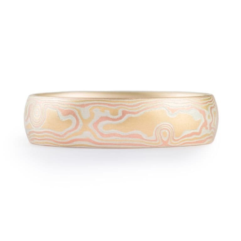 Woodgrain patterned mokume gane ring, plain band with a low dome profile and etched finish, and the ring is made of layers of red gold, yellow gold and silver.