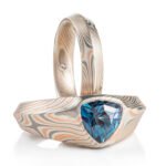 mokume gane ring set, both have an angular beveled profile, both made of combination of red gold palladium and silver, one ring has a large triangular alexandrite set into it