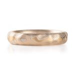 red gold, yellow gold and silver carved mokume ring. hand forged and hand carved. looks like gold islands floating above silver and red lines like a river of metal