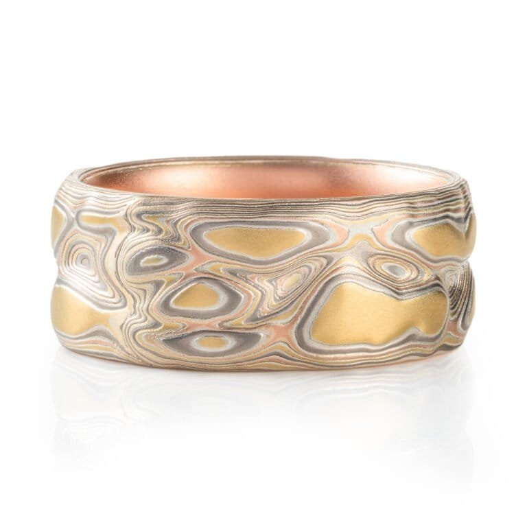 mokume gane ring, carved to create topographic texture, metals used are yellow gold red gold palladium and sterling silver