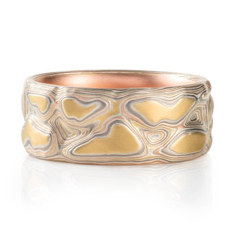 mokume gane ring, carved to create topographic texture, metals used are yellow gold red gold palladium and sterling silver