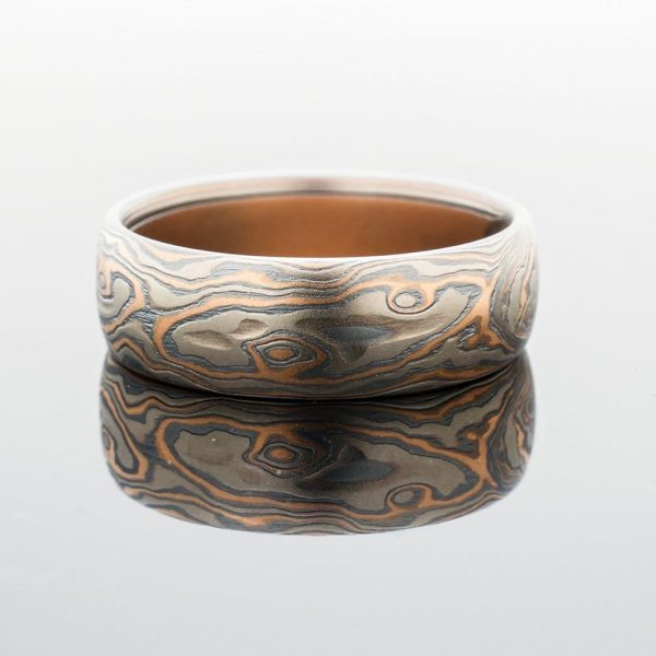 Mokume gane ring in woodgrain pattern and red gold palladium and oxidized silver