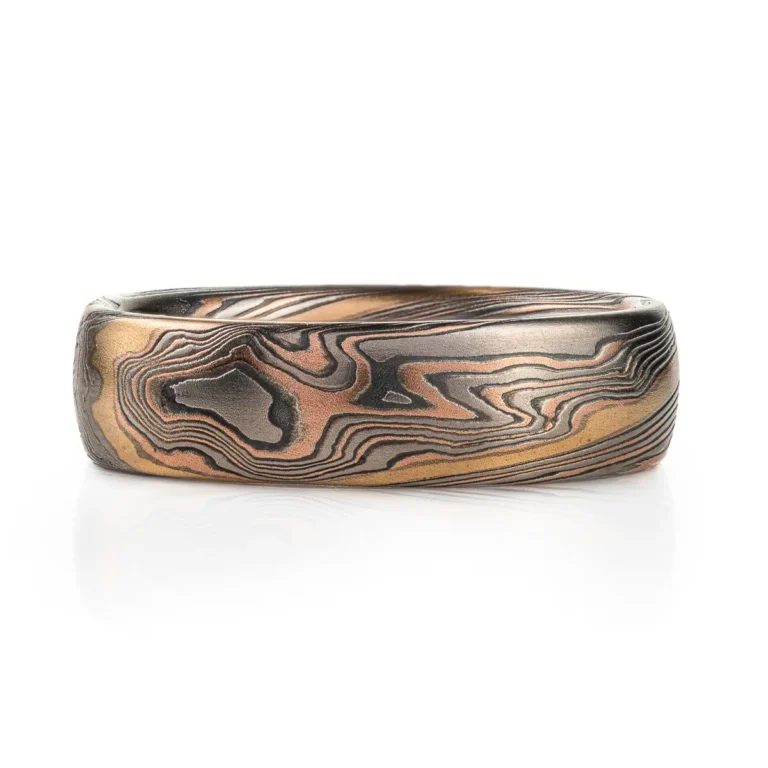 twisted mokume gane band patterned with an added gold stratum for contrast, main palette of the ring is red gold, palladium and oxidized silver