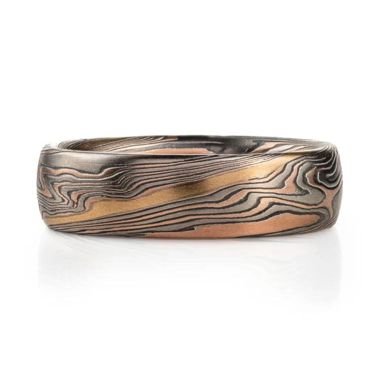 twisted mokume gane band patterned with an added gold stratum for contrast, main palette of the ring is red gold, palladium and oxidized silver