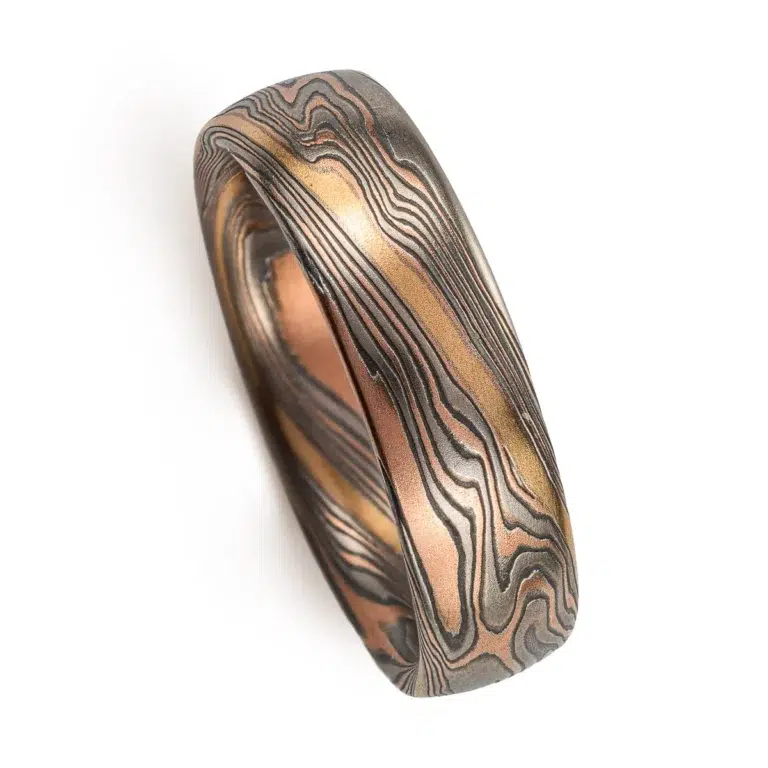 twisted mokume gane band patterned with an added gold stratum for contrast, main palette of the ring is red gold, palladium and oxidized silver