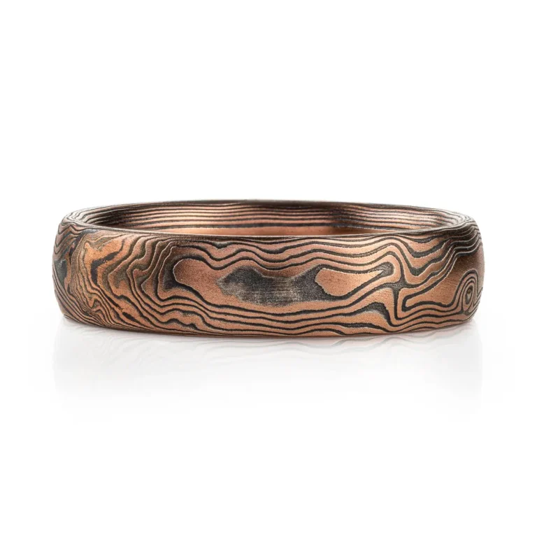 Red gold mokume gane ring with oxidized silver in a woodgrain pattern