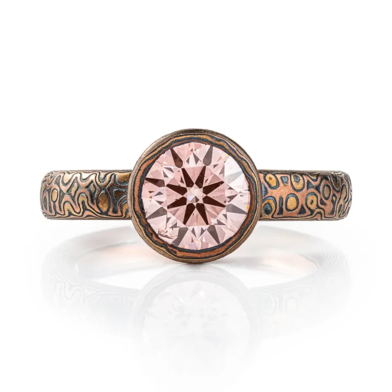 pink diamond mokume gane ring, with patterned bezel to match band, pink stone with red gold yellow gold and oxidized silver