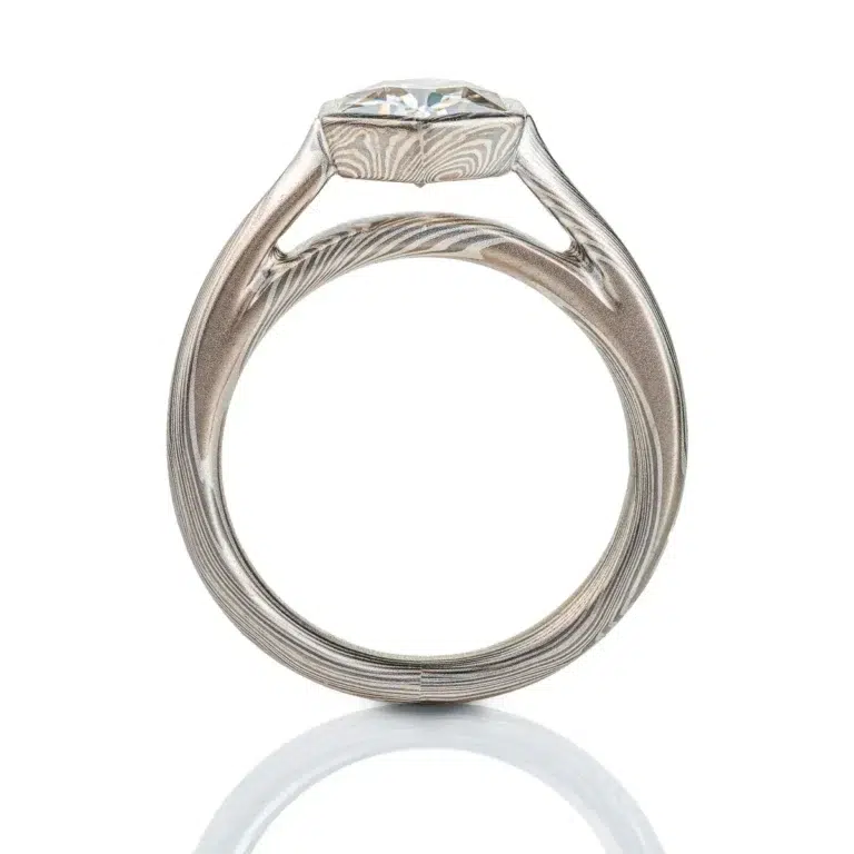 beautiful mokume gane ring with hexagon shaped moissanite in a floating mokume bezel with a light silvery palette