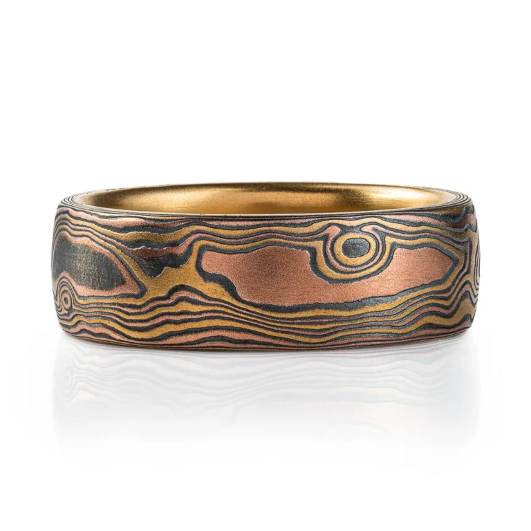 18kt yellow gold mokume gane ring in woodgrain pattern with domed profile, ring is made with golds and oxidized silver