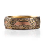 18kt yellow gold mokume gane ring in woodgrain pattern with domed profile, ring is made with golds and oxidized silver