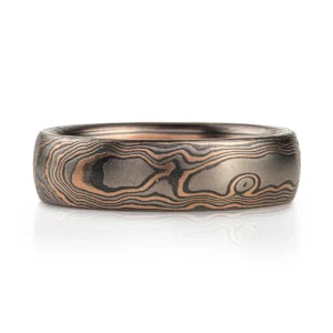 dark rustic feeling mokume gane ring in woodgrain pattern, with red gold, palladium and oxidized silver