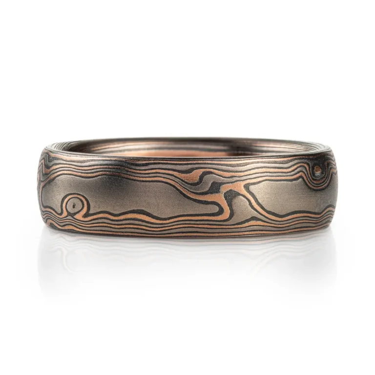 dark rustic feeling mokume gane ring in woodgrain pattern, with red gold, palladium and oxidized silver