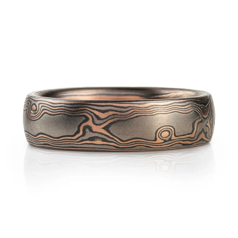 dark rustic feeling mokume gane ring in woodgrain pattern, with red gold, palladium and oxidized silver