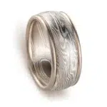 mokume gane twisted pattern ring made of layers of metal in different shades of gray, the ring also has added rails running around the top and bottom edges