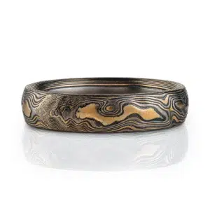 mokume gane woodgrain patterned ring with etched and textured finish, made with yellow gold, palladium and oxidized silver