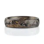 mokume gane woodgrain patterned ring with etched and textured finish, made with yellow gold, palladium and oxidized silver