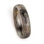 mokume gane woodgrain patterned ring with etched and textured finish, made with yellow gold, palladium and oxidized silver