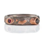 dimensional mokume gane patterned ring made to resemble rocks, with a dark diamond crystal set into it