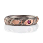 dimensional mokume gane patterned ring made to resemble rocks, with a dark diamond crystal set into it