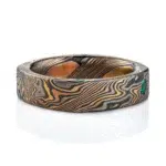 flat band made in soft square shape and rounded interior, made in mokume gane twist style pattern, with flush set small green stone