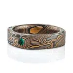 flat band made in soft square shape and rounded interior, made in mokume gane twist style pattern, with flush set small green stone