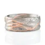 mokume gane patterned ring made to resemble rocky terrain, with a vein of red gold running through the ring in contrast to the silver