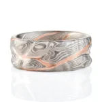 mokume gane patterned ring made to resemble rocky terrain, with a vein of red gold running through the ring in contrast to the silver